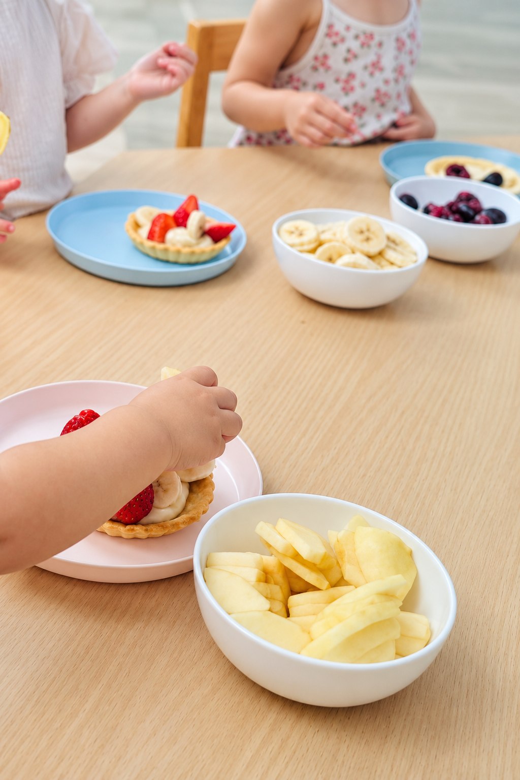 Mains d’enfants préparant des tartelettes aux fruits